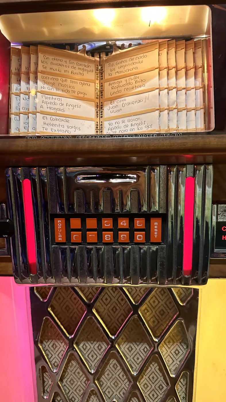 Tarjetero de canciones y botonera iluminada de una rockola